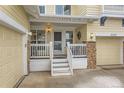 Charming front porch with stone pillars, a white railing, and a well-lit entryway at 8385 Briar Trace Dr, Castle Pines, CO 80108