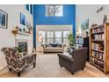 Bright living room with soaring ceilings, large windows, a cozy fireplace, and stylish furnishings at 8385 Briar Trace Dr, Castle Pines, CO 80108