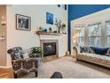 Bright living room with a fireplace and neutral colored plush carpeting at 8385 Briar Trace Dr, Castle Pines, CO 80108