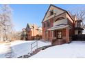 Attractive brick home on tree-lined street with snow on the ground at 1340 N Gilpin St, Denver, CO 80218