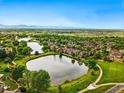 Picturesque aerial shot of townhomes and community ponds nestled within vibrant green spaces, under a clear sky at 3240 W 114Th Cir # D, Westminster, CO 80031