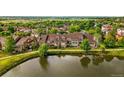 Charming view of lakeside townhomes with patios, showcasing serene water views and lush landscaping at 3240 W 114Th Cir # D, Westminster, CO 80031