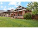Beautiful red brick bungalow with a covered front porch and lush green lawn at 2765 W Denver Pl, Denver, CO 80211