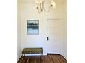 Bright hallway with hardwood floors, decorative lighting, and art piece with a tufted green bench at 2765 W Denver Pl, Denver, CO 80211