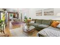 Bright living room with hardwood floors, large green sofa, and modern decor with an open floor plan at 2765 W Denver Pl, Denver, CO 80211