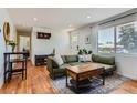Inviting living room showcases hardwood floors, a cozy green sofa, and a view into the home at 3775 S Green Ct, Englewood, CO 80110
