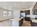Bright, modern kitchen with stainless steel appliances, island, and dark cabinets, offering a clean aesthetic at 1978 S Haleyville Way, Aurora, CO 80018