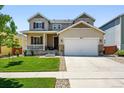Attractive two-story home featuring a manicured lawn and a two-car garage with stone accents at 16975 Melody Dr, Broomfield, CO 80023