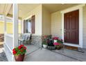 Welcoming front porch with stone accents, potted plants, and a charming seating area by the front door at 16975 Melody Dr, Broomfield, CO 80023