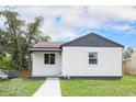 Quaint one-story home featuring a clean white exterior and freshly landscaped front yard at 2 S Knox Ct, Denver, CO 80219