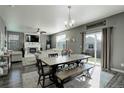 Open-concept dining area featuring a large table, chairs, a bench and a sliding glass door at 975 Alta St, Lochbuie, CO 80603