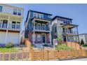 Charming exterior of a three-story home with a blue facade, brick accents, and a fenced front yard at 11063 Shining Star Cir, Parker, CO 80134