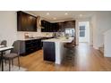 Modern kitchen with dark cabinetry, white countertops, and a spacious island with seating at 11063 Shining Star Cir, Parker, CO 80134