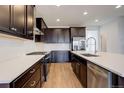 Modern kitchen featuring dark cabinetry, stainless steel appliances, and a large island with white countertops at 11063 Shining Star Cir, Parker, CO 80134