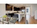 Modern kitchen with dark cabinetry, stainless steel appliances, and a large island with barstool seating at 11063 Shining Star Cir, Parker, CO 80134