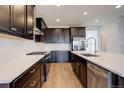 Modern kitchen features sleek, dark cabinets, white subway tile backsplash, and stainless steel appliances at 11063 Shining Star Cir, Parker, CO 80134