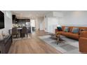 Open-concept living room with dining area, hardwood floors, and a modern kitchen view at 11063 Shining Star Cir, Parker, CO 80134