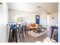 Inviting living room with modern bar stools, stylish decor, and natural light, creating a warm and welcoming space at 6190 Ivy St, Commerce City, CO 80022