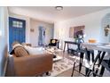 Cozy living room featuring a blue front door, stylish decor, and an inviting open floor plan; perfect for entertaining at 6190 Ivy St, Commerce City, CO 80022