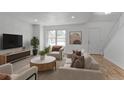 Bright living room with contemporary furnishings, hardwood floors, and a large window at 6579 Ingalls St, Arvada, CO 80003