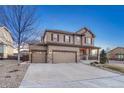 Attractive two-story home with a three-car garage, stone accents, well-kept lawn, and inviting front porch at 7310 Blue Water Dr, Castle Rock, CO 80108