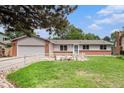 Well-maintained ranch home with a manicured lawn, pretty flower beds, and an attached garage at 3272 S Joplin Ct, Aurora, CO 80013