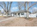 Charming single-story home with white siding, black trim, and a well-maintained front yard at 1857 W Tennessee Ave, Denver, CO 80223