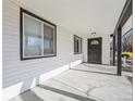 Covered porch with a black front door and a modern light fixture at 1857 W Tennessee Ave, Denver, CO 80223