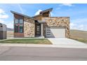 Modern two-story home boasts stone accents, a two-car garage, and a professionally landscaped front yard at 5741 Doc Bar Circle, Larkspur, CO 80118