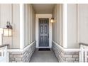 Front entry with gray door, stone accents, and light fixtures at 13352 E 110Th Way, Commerce City, CO 80022