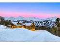 Beautiful exterior of mountain home with snow covered roof, stone accents, and mountain view at 250 Sallie Barber Rd, Breckenridge, CO 80424