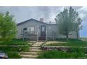 Attractive single-story house with a welcoming front porch and landscaped garden in a peaceful setting at 47904 Dartmouth Ave, Bennett, CO 80102