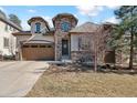 Charming home with stone accents, a two-car garage, and a manicured front lawn at 6875 Northstar Ct, Castle Rock, CO 80108