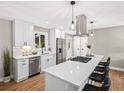 Bright kitchen featuring stainless steel appliances, white cabinets, and an island with seating at 9120 W 3Rd Pl, Lakewood, CO 80226