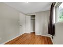 Bedroom with hardwood floors, closet with bi-fold doors and a window with curtains at 8881 Judson St, Westminster, CO 80031