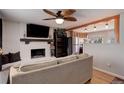 Comfortable living room with a white brick fireplace, open to the kitchen area, and hardwood flooring at 8881 Judson St, Westminster, CO 80031