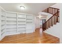 Bright living room with hardwood floors, built-in bookshelves, and an open staircase with wood railing at 9118 W 50Th Ln # 5, Arvada, CO 80002