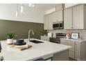 The kitchen is equipped with stainless steel appliances, a stylish tile backsplash and a large sink at 6153 N Ceylon St # 102, Denver, CO 80249