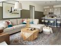 Comfortable living room with a large sectional sofa, modern coffee table, and open access to the kitchen at 6153 N Ceylon St # 102, Denver, CO 80249