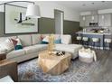 Comfortable living room with a large sectional sofa, modern coffee table, and open access to the kitchen at 6153 N Ceylon St # 102, Denver, CO 80249