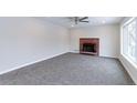 Bright living room with a ceiling fan, a brick fireplace, fresh paint, and large windows at 10799 Murray Dr, Northglenn, CO 80233