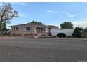 Charming single story home with brick accents and manicured front yard landscaping at 1009 Bush St, Brighton, CO 80601