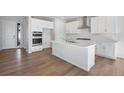 Bright kitchen featuring white cabinetry, a central island, and modern stainless steel appliances at 10022 Wheeling St, Commerce City, CO 80022