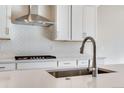 Close-up of a modern kitchen island with a sink, faucet, and a white countertop at 10022 Wheeling St, Commerce City, CO 80022