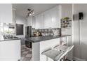 Bright kitchen with stainless appliances, breakfast bar, and white cabinets offering a seamless design with a stylish backsplash at 800 N Washington St # 804, Denver, CO 80203