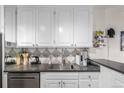 Bright kitchen features gray countertops, white cabinetry, and stainless steel dishwasher at 800 N Washington St # 804, Denver, CO 80203