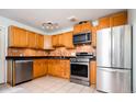 Traditional kitchen with stainless steel appliances, oak cabinetry, and black countertops at 1735 S Wyandot St, Denver, CO 80223