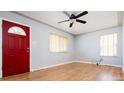 Bright living room with hardwood floors, natural light, ceiling fan, and a striking red front door at 1735 S Wyandot St, Denver, CO 80223