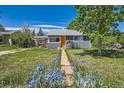 Inviting home exterior featuring a well-manicured lawn and blooming flowers at 1271 Uinta St, Denver, CO 80220