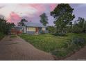 Charming home with a well-maintained lawn and a striking orange front door at 1271 Uinta St, Denver, CO 80220